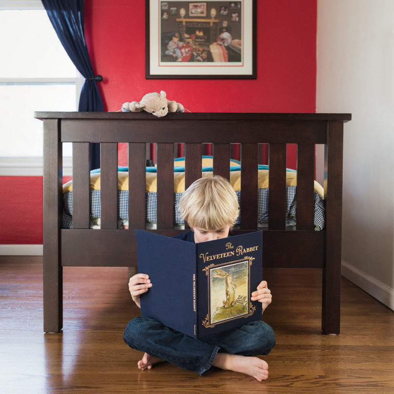 A boy reads "The Velveteen Rabbit" while his own Real lovey reads over his shoulder.