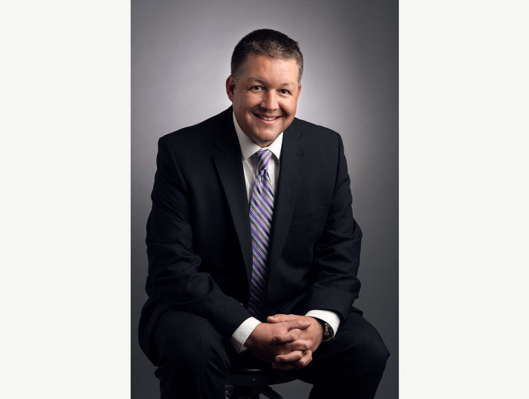 Branding photograph of pain management physician leaning forward and engaging with the viewer.