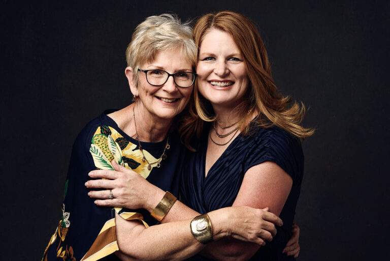 Mother and daughter hug during their professional photo session.