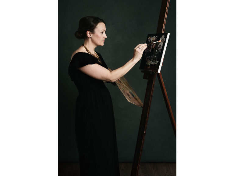 Portrait of a painter, touching up her work on a canvas